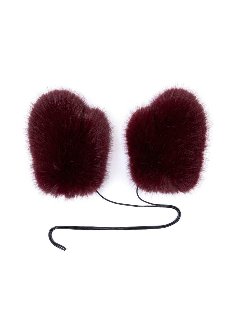 Flatlay image on white background of burgundy faux fur mittens from de Savary London with leather tie.