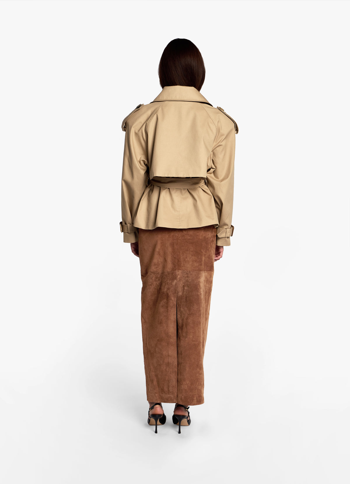Back view of model in cotton trench jacket with collar down, wearing with mocha suede pencil skirt.