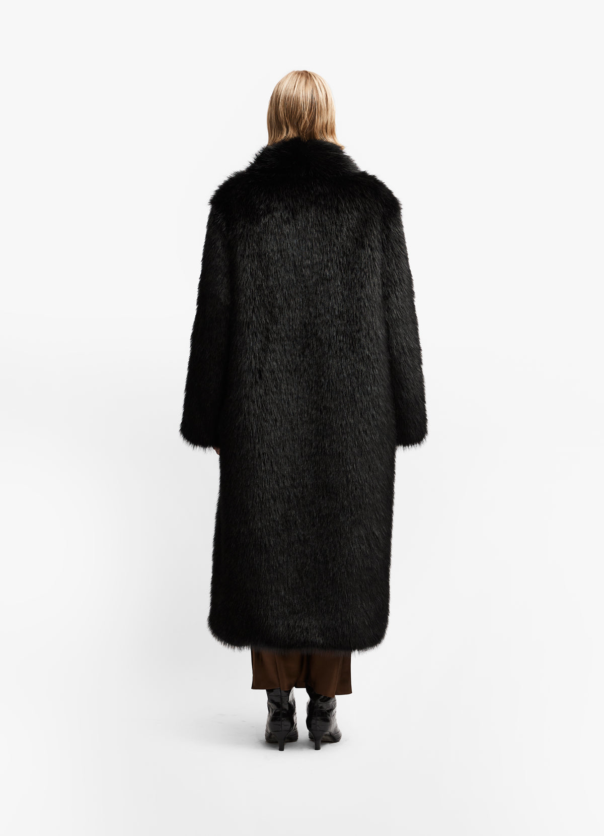 Back view of model wearing luxe black faux fur maxi length against white background.