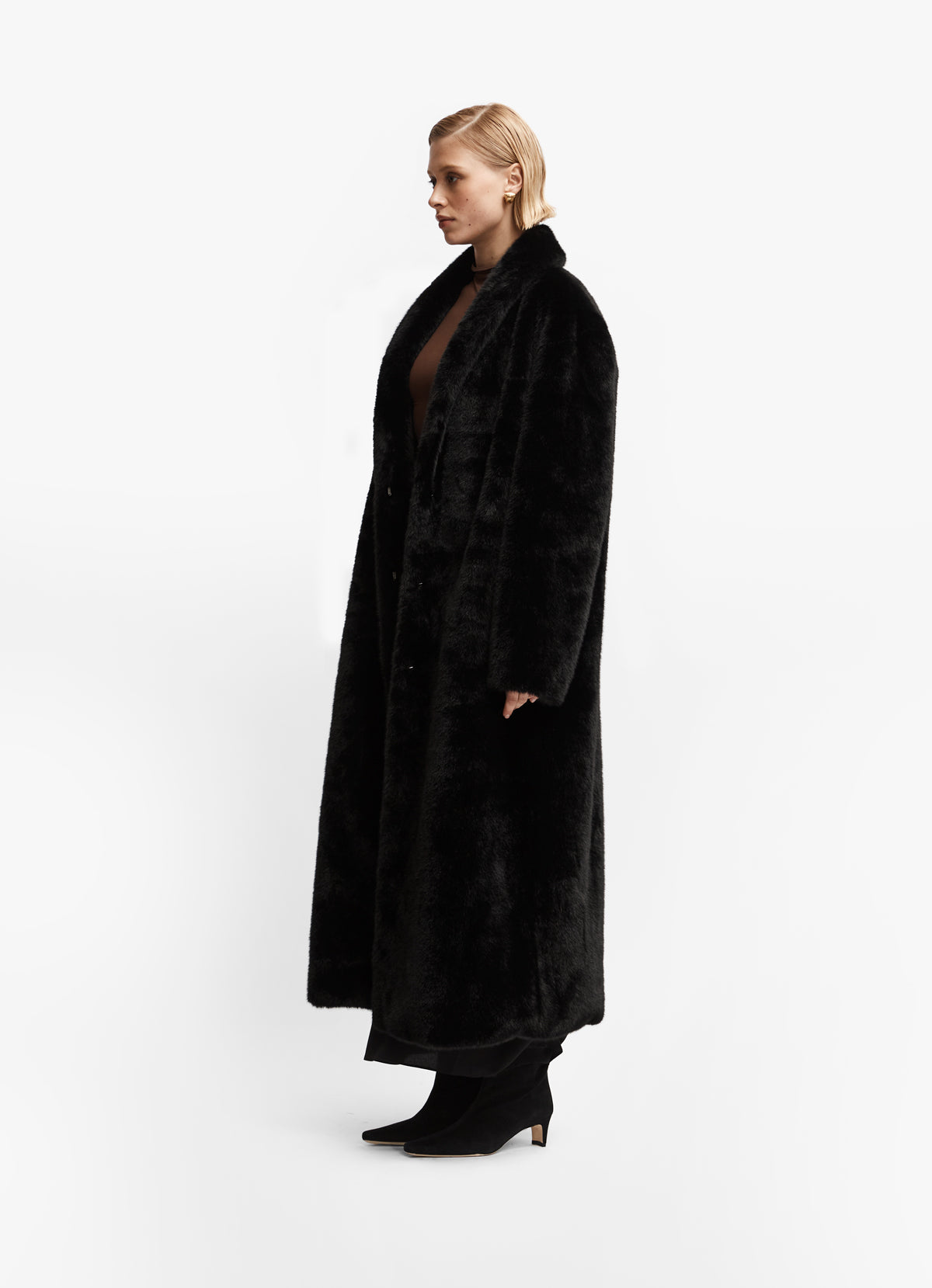 Side view of black faux fur maxi coat in tall verison.