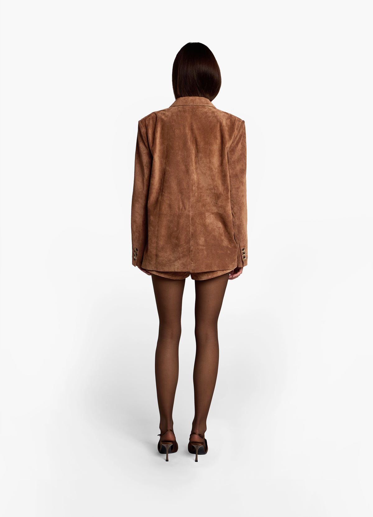 Back view of model wearing mocha suede blazer, showing button detail on sleeve cuff.